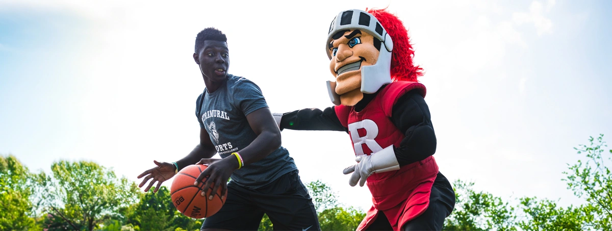 Student playing basketball with Scarlet Knight